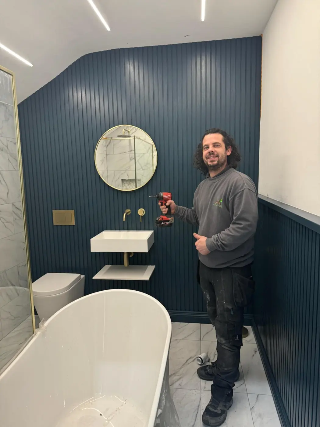 Ash in a finished bathroom with navy slatted walls