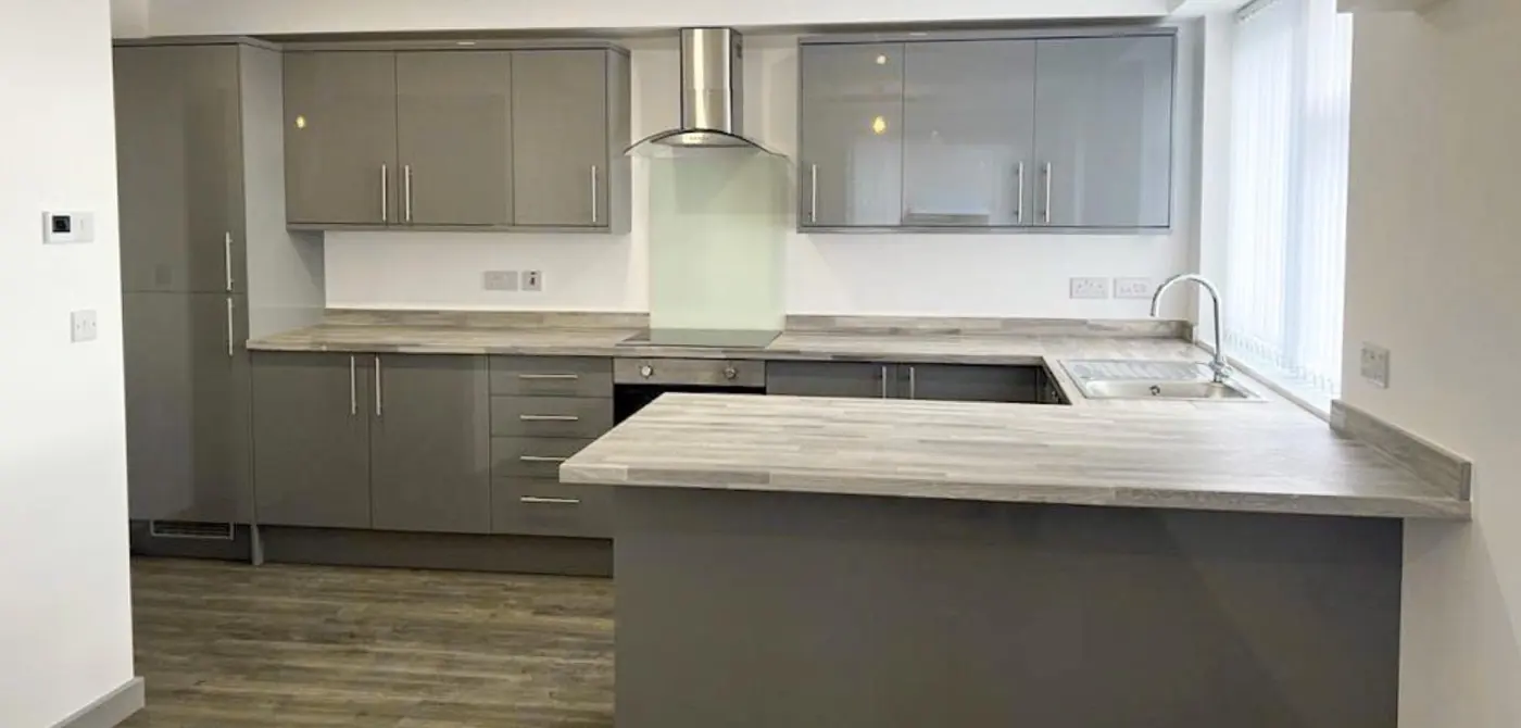 Grey gloss apartment kitchen with breakfast bar