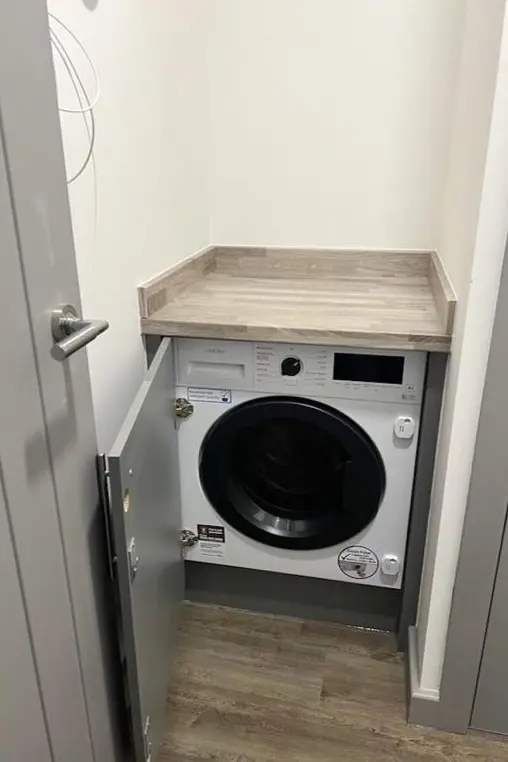 Integrated washing machine housing in a grey apartment kitchen