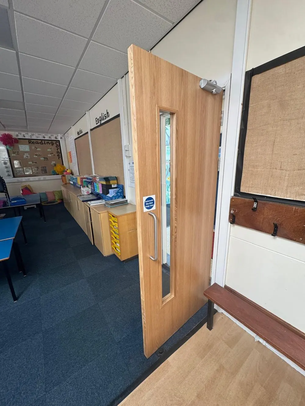 Oak-veneer classroom fire door with vision panel and overhead closer