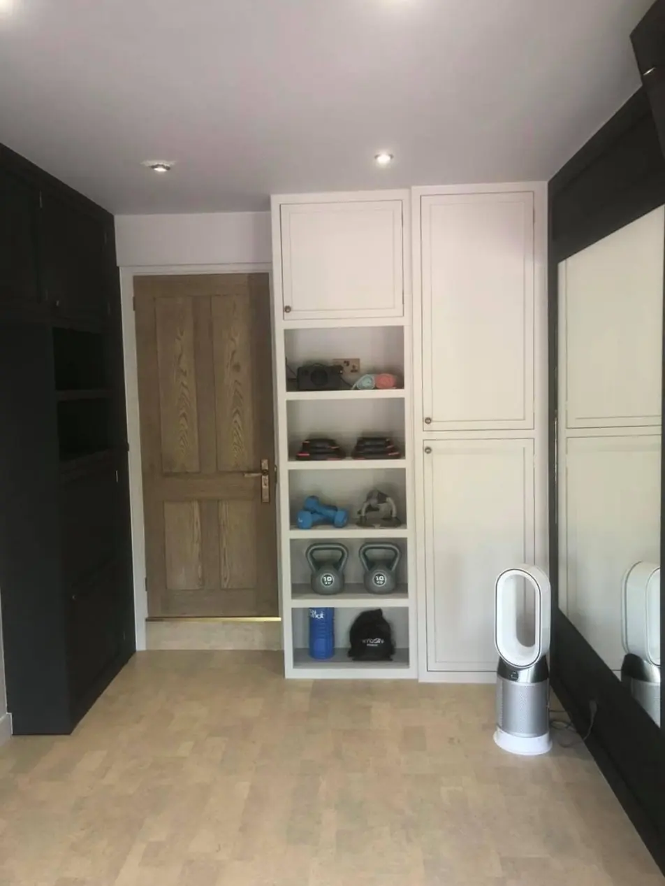 Painted storage units and shelving in a garage gym conversion