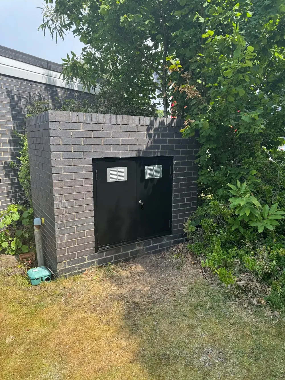 Brick gas meter enclosure with lockable, vented steel doors