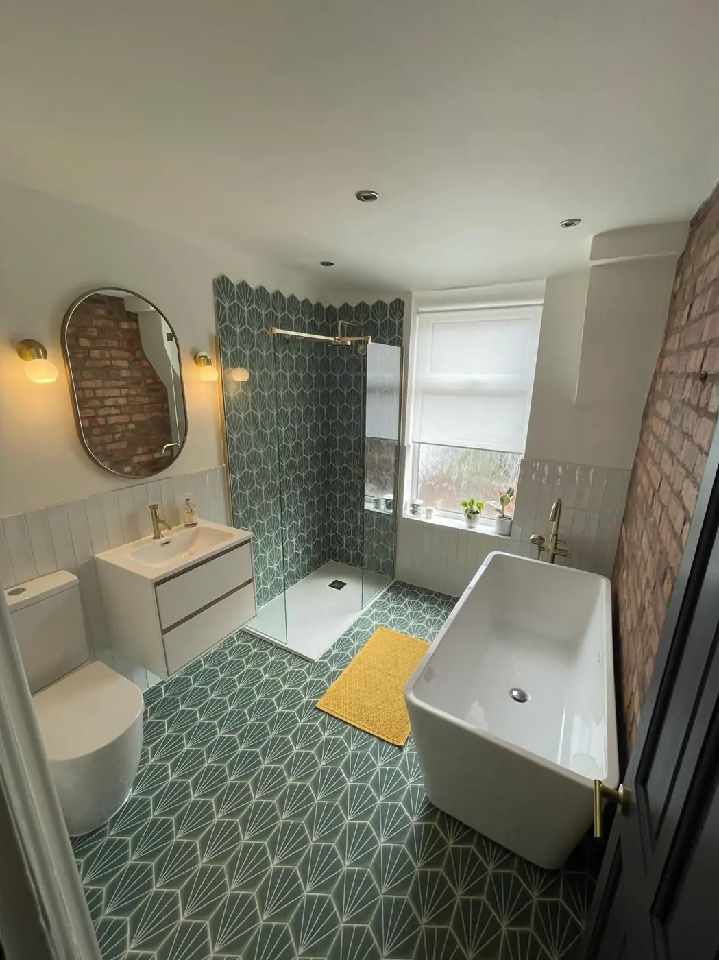 Bathroom with green patterned floor tiles and freestanding bath