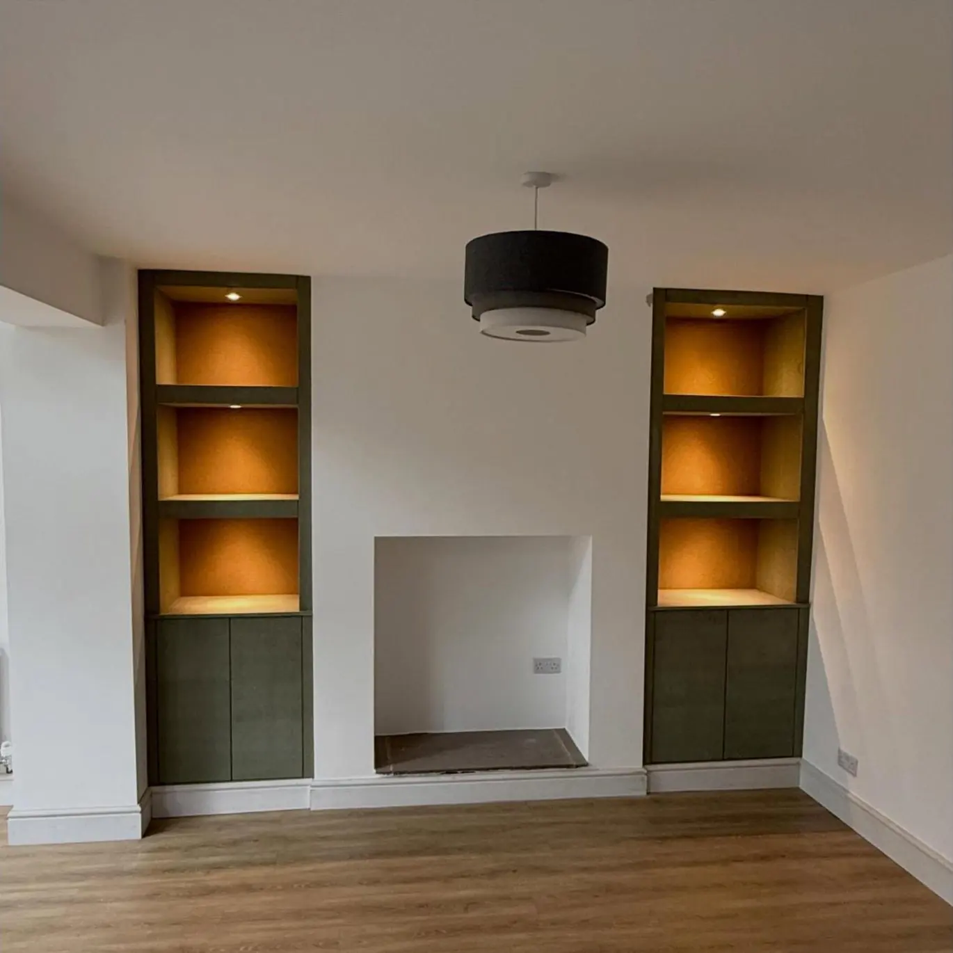 Alcove units with lit floating shelves and cupboards