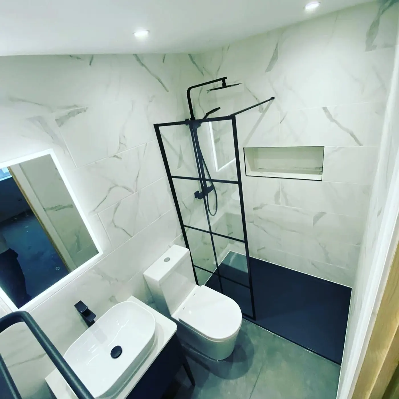 Marble-effect shower room with black framed screen