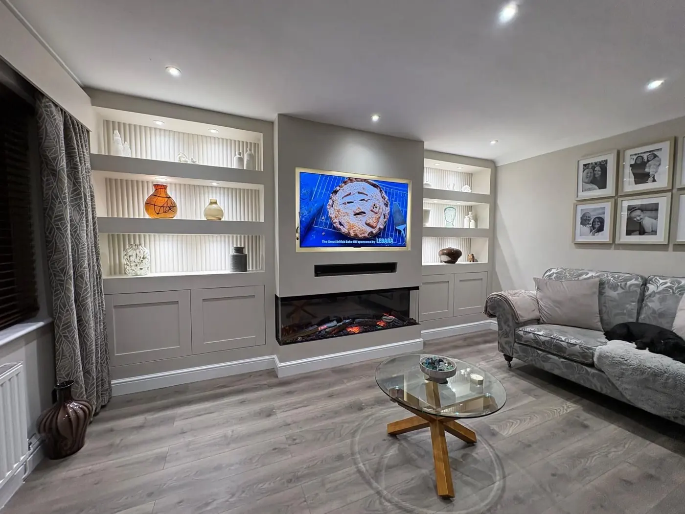 Media wall with fire and lit alcove shelving