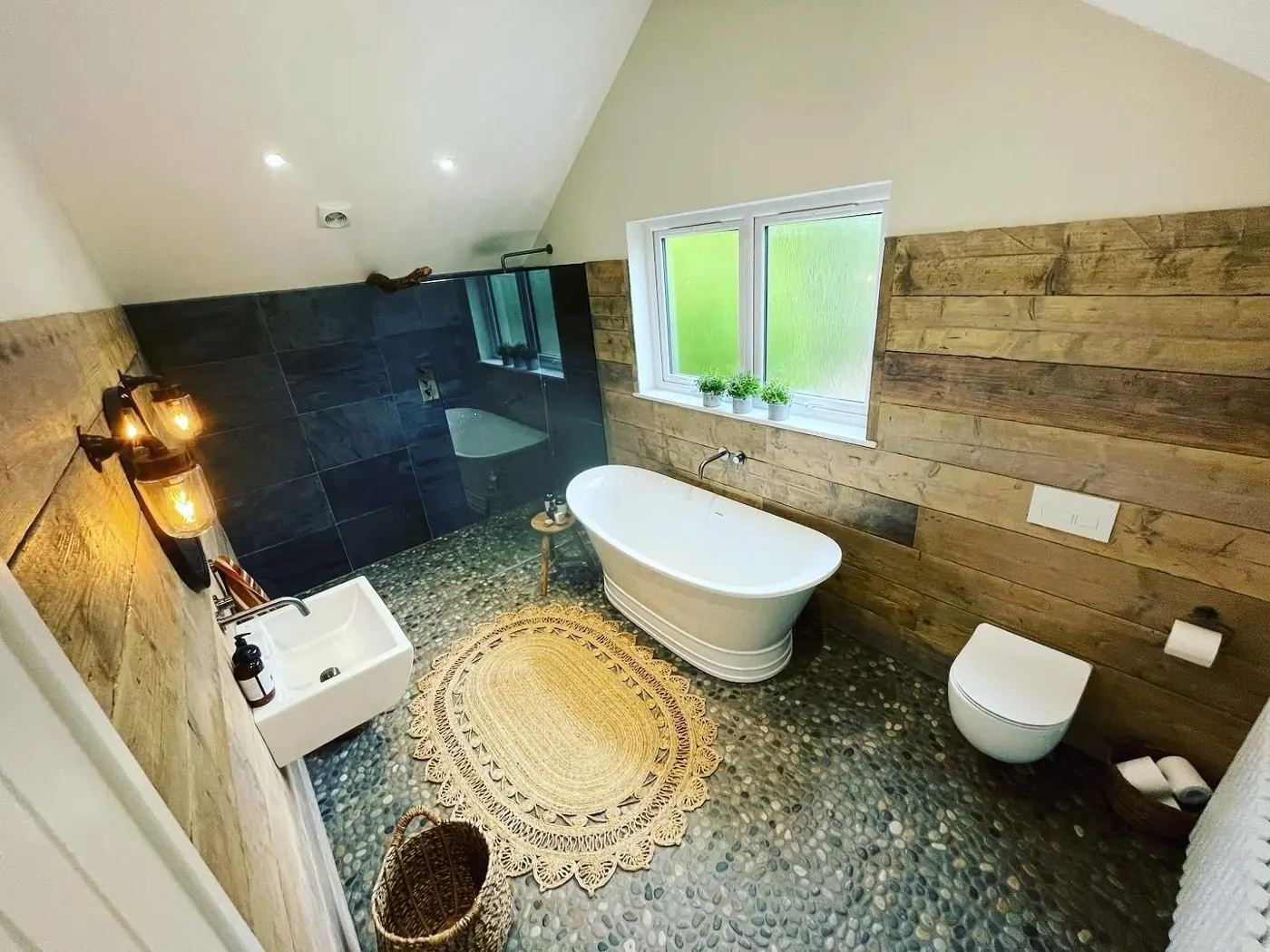 Bathroom with reclaimed timber cladding and pebble floor