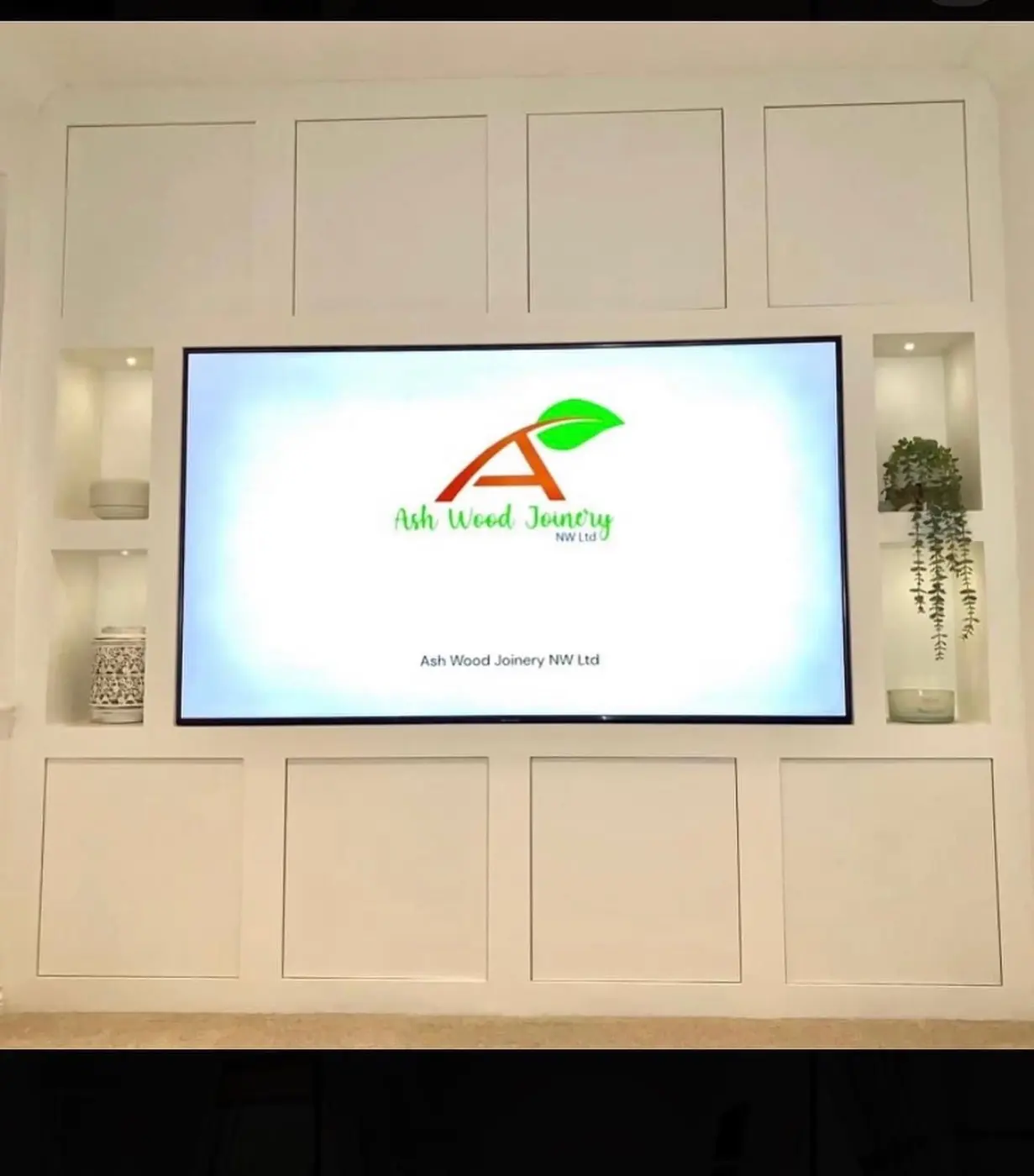 White panelled media wall with lit niches